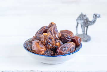 Date fruits for Moroccan tea drinking in traditional plate on white background.