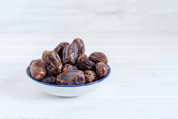 Date fruits on white wooden background with copy space.