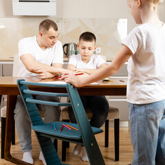 Fototapeta premium learning at home, children in the kitchen studying while the whole family is sitting at the table with them
