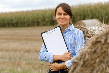 Beautiful girl agronomist with note book and analyzes the corn crop