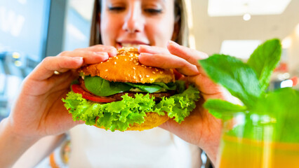 Veggie sandwich healthy vegan burger. Cute cheerful girl eating vegetarian hamburger with salad,...