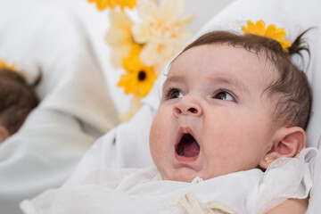 detail shot of a beautiful six months old baby girl, yawning, sleepy after being fed by her mother....