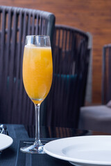 A glass of orange freshly squeezed natural juice on a table in a restaurant. Proper nutrition. vertical composition.