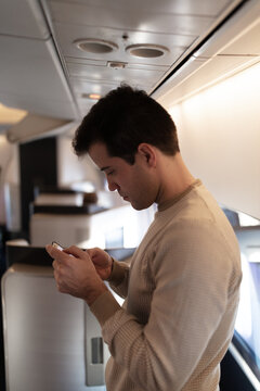Man in first class cabin checkinb mobile phone
