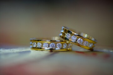 Wedding rings for weddings lie on a mirror reflecting surface.