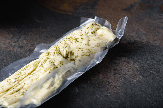 Cheese Pigtail with Dill Packed in Vacuum Bag. Grocery Goods on Dark plane. Snack for Beer.