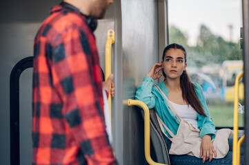Portrait of a beautiful caucasian woman sitting in a bus while traveling in the city. Young female...