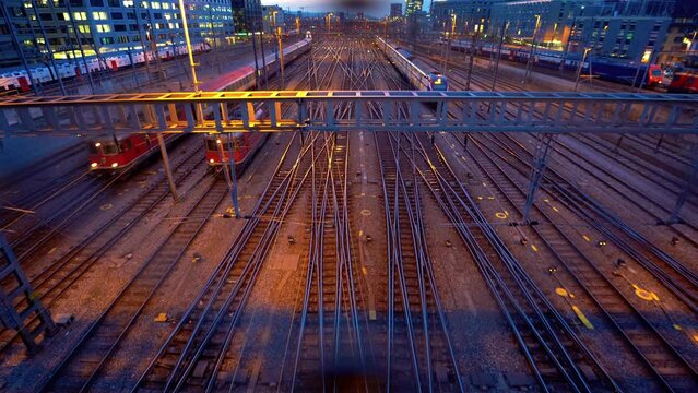 Two trains coming in the railway station via tracks of the Zurich main station filmed from the platform bridge perspective. One old and one modern sbb fast train and locomotive.