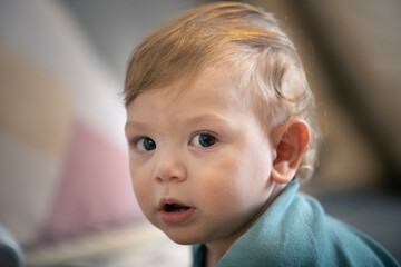 Niño bebé jugando y mirando a la cámara