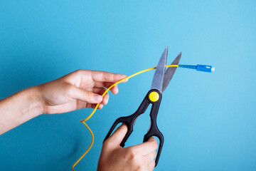 Destroy optical fiber with scissors. Isolated on blue