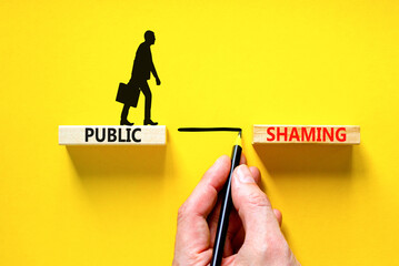 Public shaming symbol. Concept words Public shaming on wooden blocks on a beautiful yellow table...