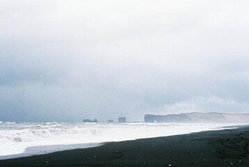 Black sand of Reynisfjara beach on the seashore. Iceland