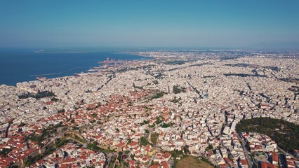 Greek sea-town concept. Drone view of numerous white-washed houses with orange roofs. Seashore on the left side. High quality photo