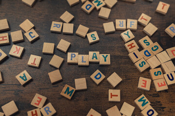 Fun idea for a game night with friends. Colourful wooden letters seen from the top creating the word PLAY. Leisure time activities. High quality photo