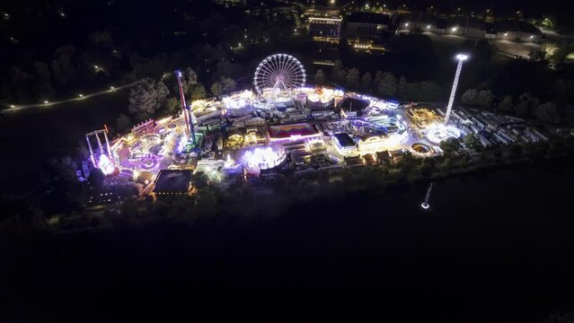 Aerial time lapse shot of a colorful fair at night next to river Danube