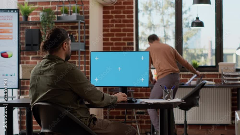 Poster male freelancer analyzing isolated greenscreen on monitor, working in startup office. using blank ch