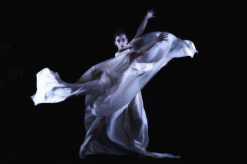 dancer in a white robe on a black background, woman dancing