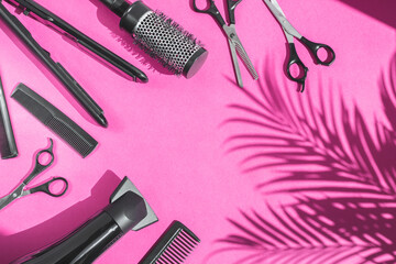 Scissors, combs, hairdryer and hair straightener on a lilac background.