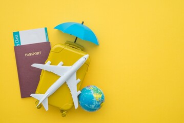 Red umbrella cover airplane, passport, flight tickets and suitcases travelers on yellow background....
