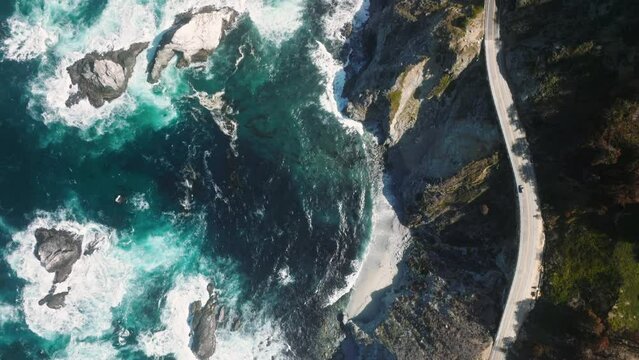 Aerial View Of Car Driving By Cinematic Rocky Ocean Coast. Beautiful Mountain Road With Scenic Ocean View. Driving On Mountain Road. Road Trip. Rocky Mountain Landscape Car Driving By Big Sur Coast 4K