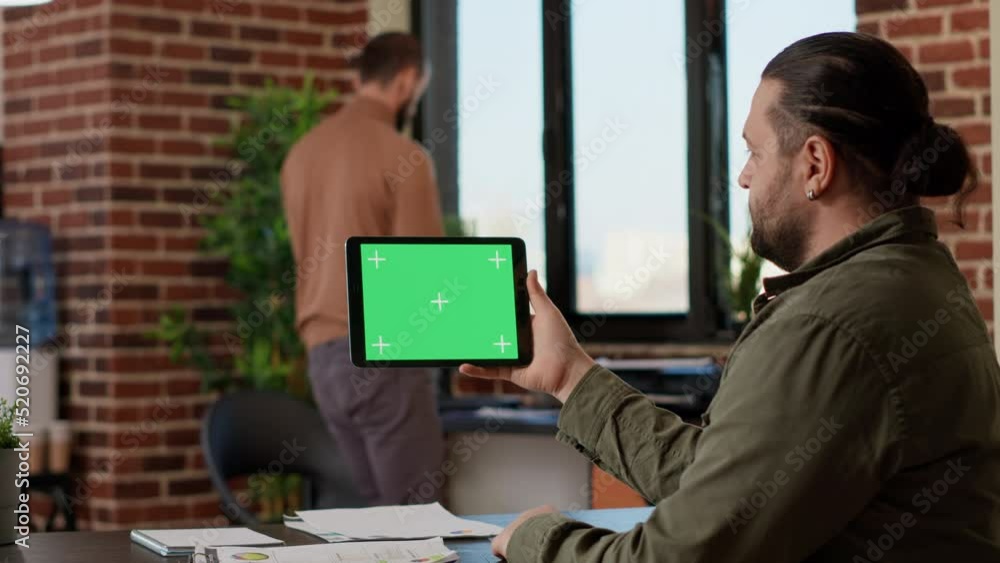 Poster office worker analyzing horizontal greenscreen on tablet, looking at blank copyspace template at job