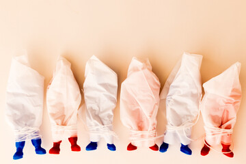 Red and blue Russian toy soldiers in plastic body bags laying in a row. Concept of Russian war casualties