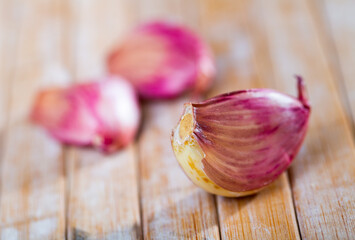 Garlic cloves over wooden background. Fresh unpeeled garlic on wooden table.