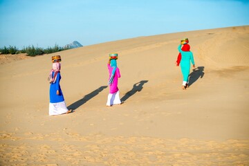 Art photo: the girls are walking in Nam Cuong sand dunes.Time: July 22, 2022. Location: Nam Cuong sand hill, Phan Rang city, Ninh Thuan province. 