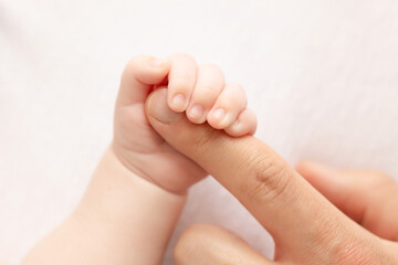 Obraz na płótnie Canvas Little baby hand holding father`s finger
