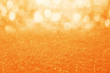 Shiny orange glitter and blurred lights on background. Bokeh effect