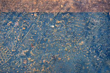Foot prints with brown dirt on blue rust colored floor tiles