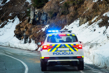 The flashing blue lights of an emergency police car vehicle on a country road in Slovenia