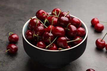 Bowl with ripe sweet cherries on grey table, closeup