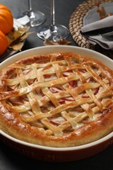 Delicious homemade apple pie and autumn decor on black table, closeup. Thanksgiving Day celebration