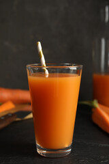 Glass of freshly made carrot juice on black table