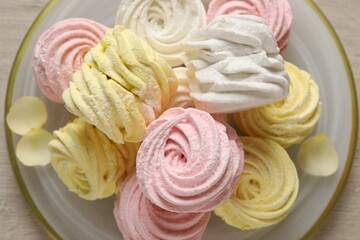 Plate with delicious marshmallows on wooden table, top view