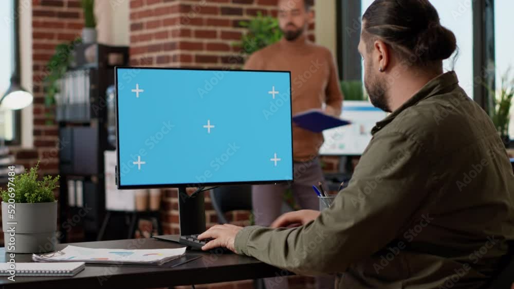 Poster company manager working with greenscreen mockup display on desktop computer, using blank copyspace t