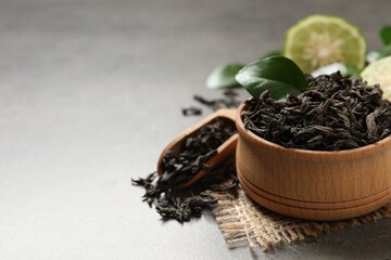 Dry bergamot tea leaves on grey table, closeup. Space for text