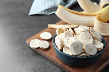 Freeze dried and fresh bananas on grey table. Space for text