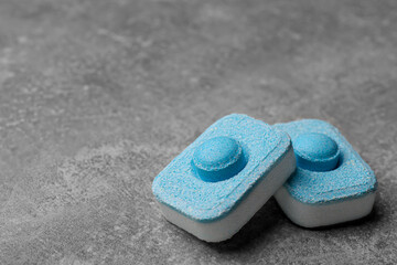 Water softener tablets on grey table, closeup. Space for text