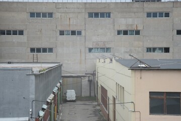 Full-color horizontal photo. Geometric composition of parts of industrial buildings. A wall with narrow windows, garages and part of the wall without windows are visible.
