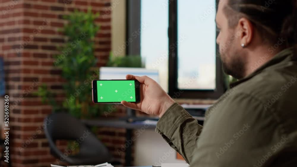 Aufkleber office employee looking at horizontal greenscreen on smartphone, analyzing isolated copyspace on tem