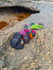 Backpack and sneakers on conglomerate sedimentary rock