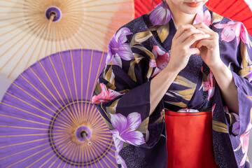 番傘の前に浴衣姿で立つ女性　JAPAN	