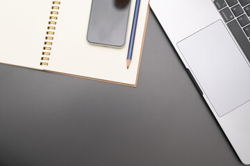 Gray desk office with laptop, smartphone and other work supplies. computer desk with keyboard,...