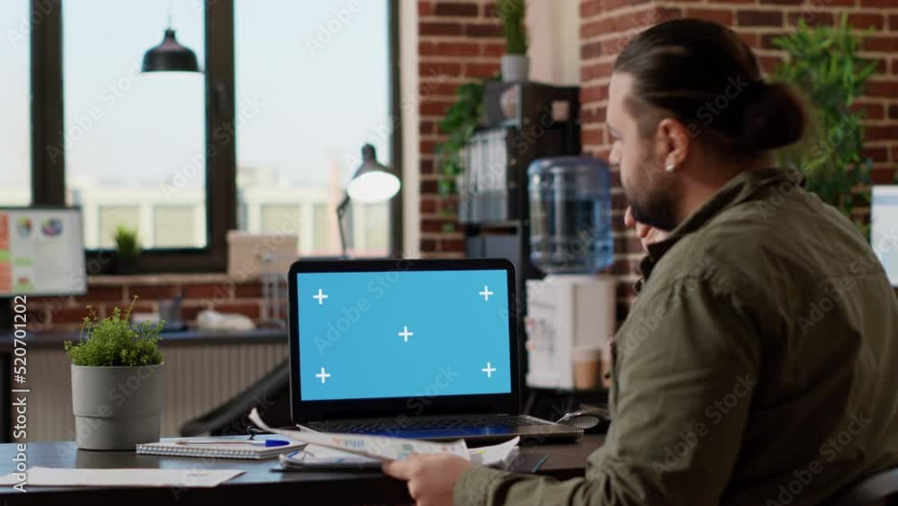 Poster office worker looking at greenscreen template on laptop, working on startup business in workplace. u