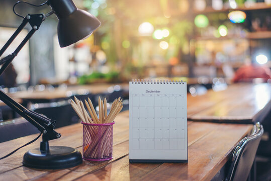 Calendar 2022 desk place on the table. Desktop Calender for Planner to plan agenda, timetable, appointment, organization, management each date, month, and year on wooden office table. Calendar Concept
