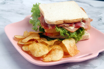 Freshly made ham, bacon and cheese sandwich