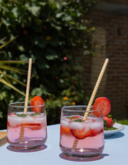 two glasses with strawberry drink and ices 