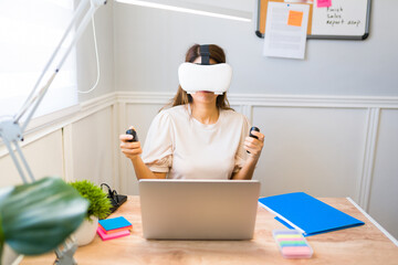 Young woman with virtual reality glasses working from home